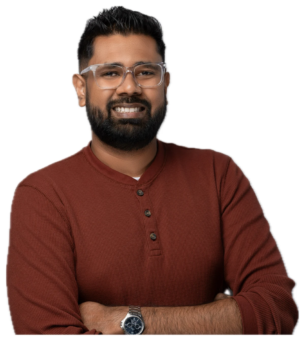 Kavindu Narathota, smiling, arms crossed, wearing glasses and a rust-coloured henley